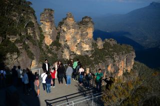 In this picture taken on May 12, 2013 people visit the 'Three Sisters' rock formation in the Blue Mountains. The Blue Mountains is a mountainous region in New South Wales, some 50 kilometers