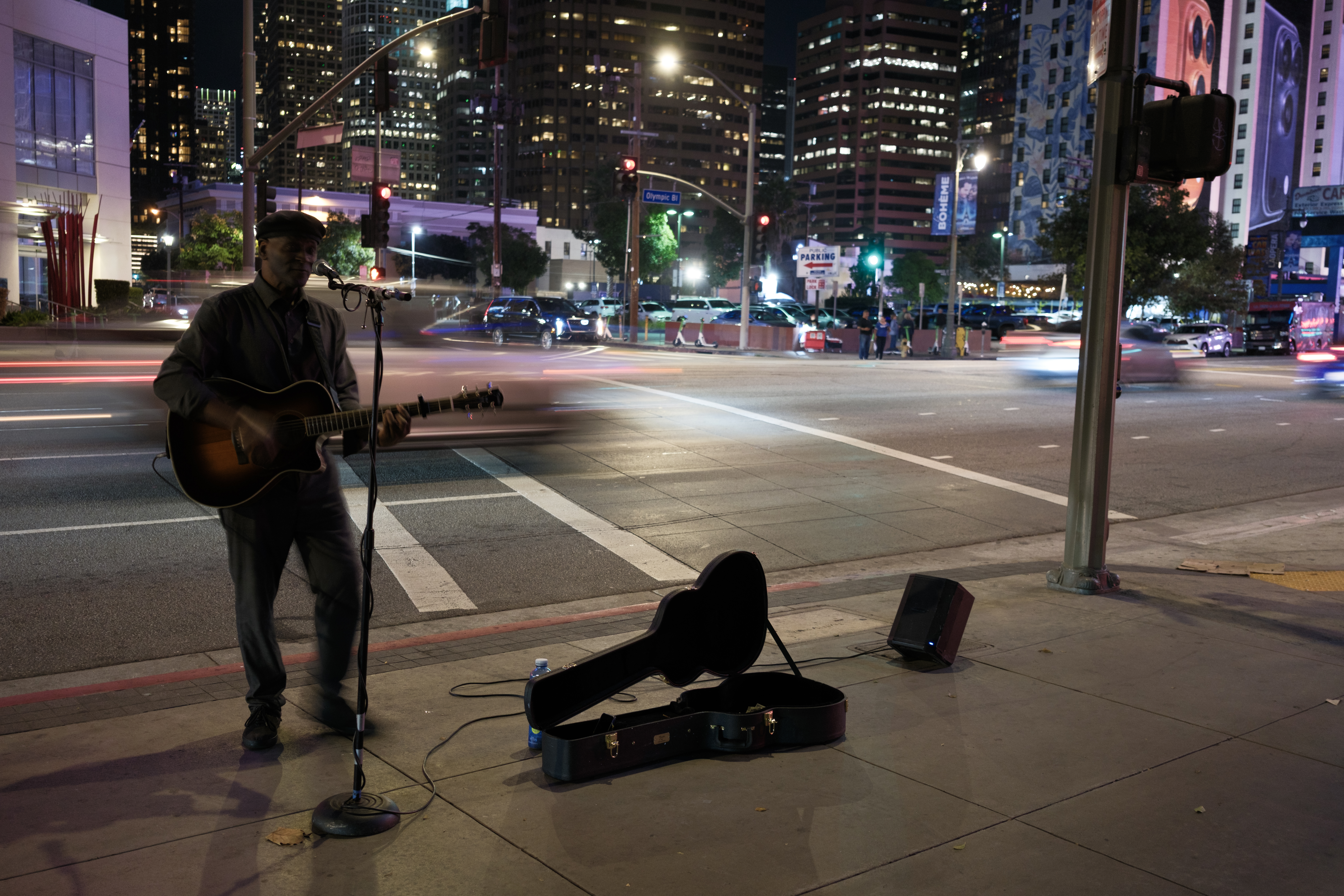 A street performer at night, with blurred traffic in the streets, edited in Adobe Camera RAW