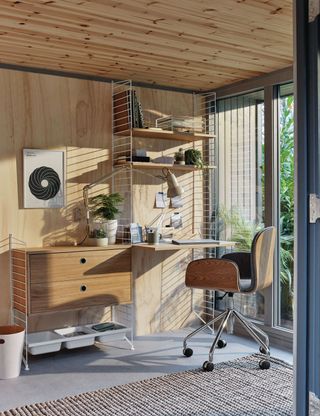 mid-century inspired outdoor office, with wooden shelving and drawers, and industrial wooden chair, and a gray textured rug