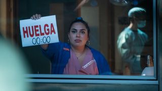 A nurse holds up a sign in the OR saying to stop at midnight