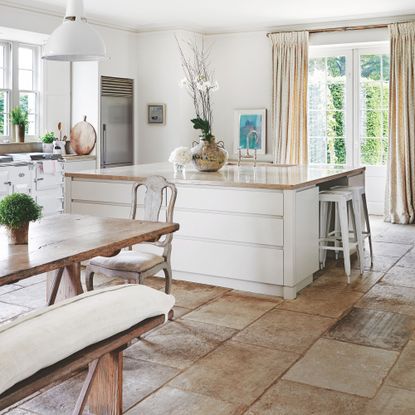Open plan kitchen diner with white unit and stone effect flooring