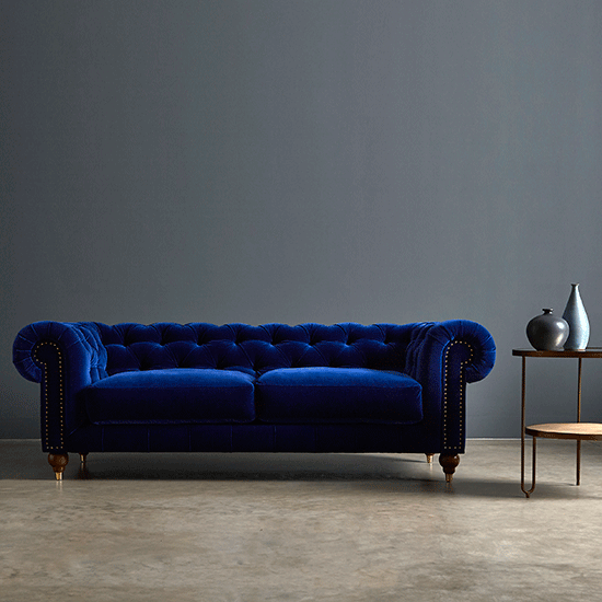 blue sofa with grey wall and table