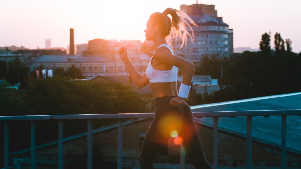 a photo of a woman running at sunrise