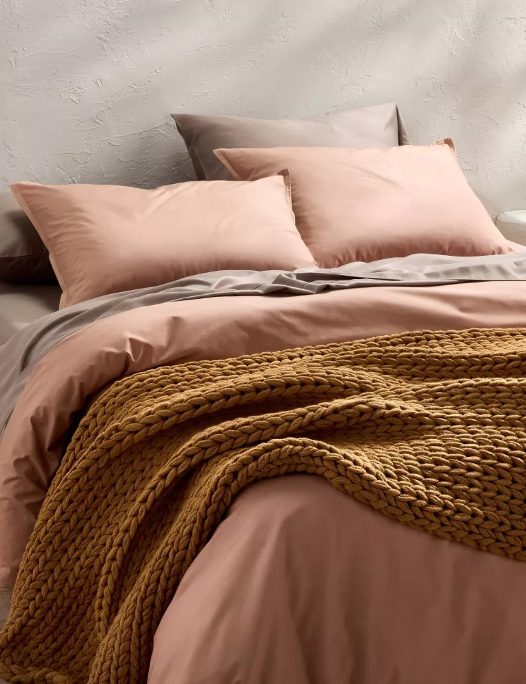 Pink and mauve Casaluna bed sheets styled on a minimalist platform bed