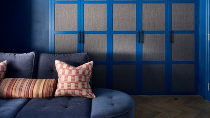 A small living room painted in a dramatic shade of blue