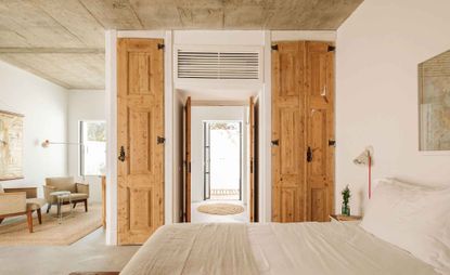 Neutral bedroom with wood closet doors at the Hospedaria hotel in Portugal