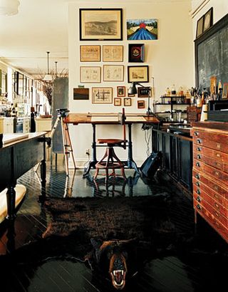 A hand-rendered, antique drafting table and bearskin rug