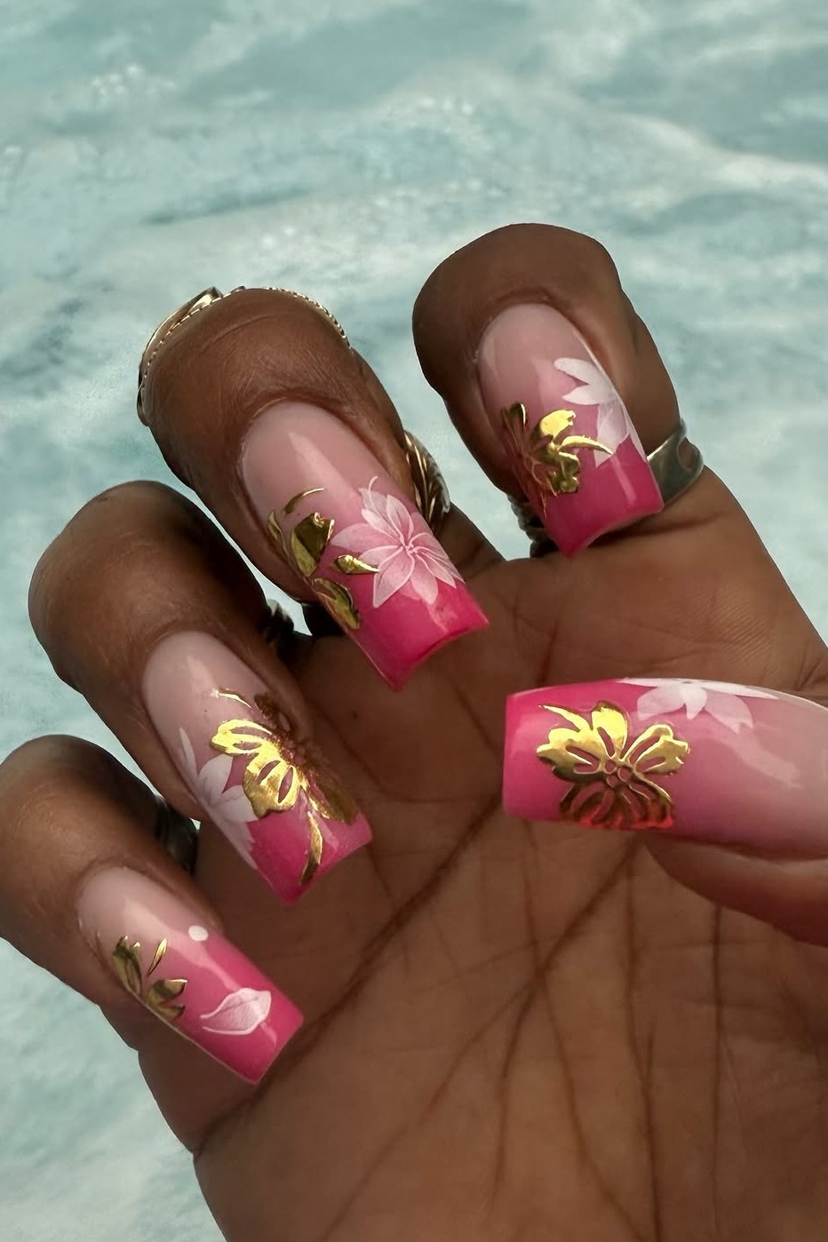 A Y2K pink hibiscus manicure.