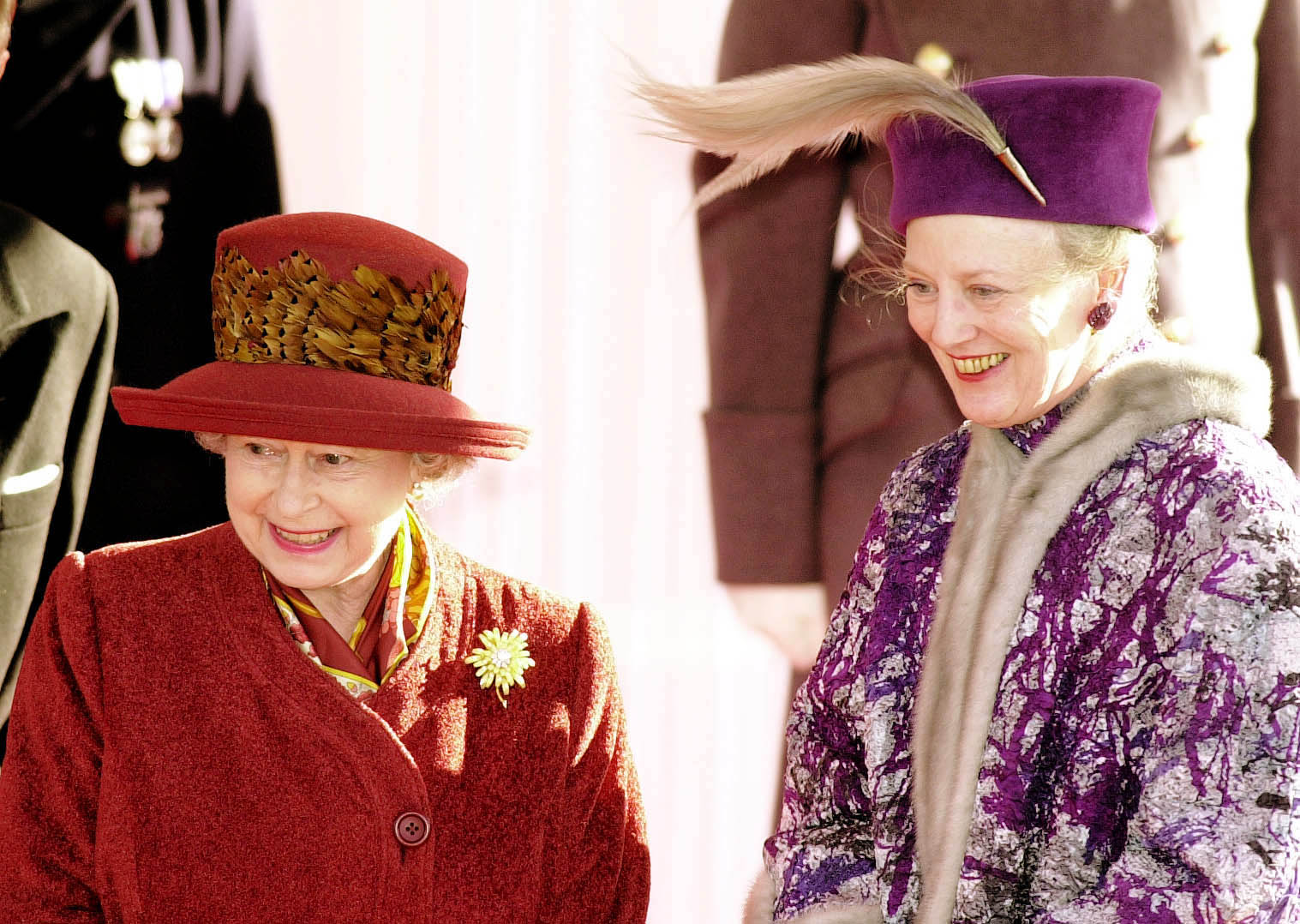 Queen Elizabeth and Queen Margrethe standing next to one another and smiling in hats