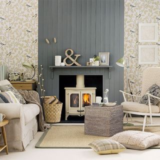 small living room with grey painted panelling and wallpaper with log burner