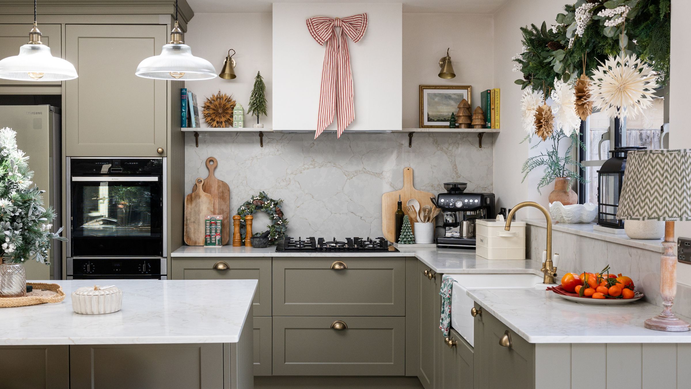 Kitchen with greige kitchen cabinets and marble worktop, covered in christmas decor and everyday kitchen items