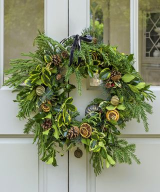 Foliage winter wreath decorated with dried citrus fruits and pinecones.