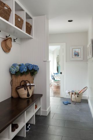 white entryway with slate tiles, white shiplap walls, mudroom