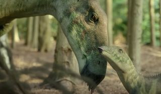 an adult dinosaur nuzzles a baby dinosaur