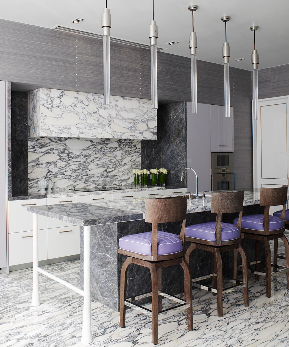 Luxury kitchen island ideas in marble, shown in a fully marble kitchen scheme with purple upholstered seating.