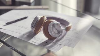 the bang & olufsen beoplay hx over-ear headphones on a desk