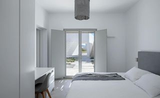 Clean white bedroom interior at KITE House in Greece