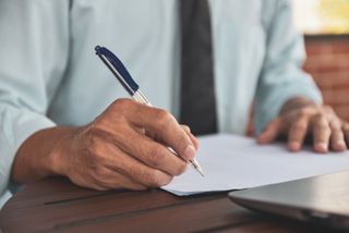 A person signing a document.