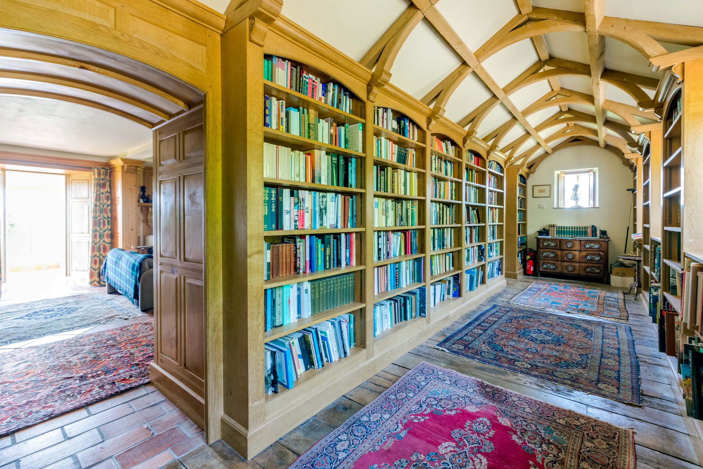 Floor-to-ceiling bookcases in the wooden library which are filled with books