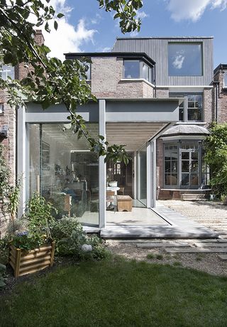 A grey aluminium framed glass extension by Edward McCann Studio