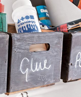 bottle of glue in grey wooden container