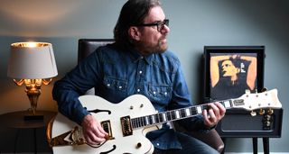 Billy Duffy is photographed at home with his new signature Falcon, which was launched by Gretsch on 13 November 2024 and is finished in Vintage White with gold hardware.