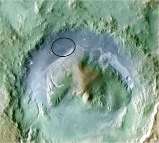 Color coding in this image of Gale Crater on Mars represents differences in elevation, with blue relatively low and tan relatively high. The vertical difference from a low point inside the landing ellipse for NASA's Mars Science Laboratory to a high point on the mountain inside the crater is about 3 miles (5 kilometers).