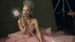 Ariana Grande in costume as Glinda the Good Witch on the set of Wicked wearing a french manicure and a pink ballgown