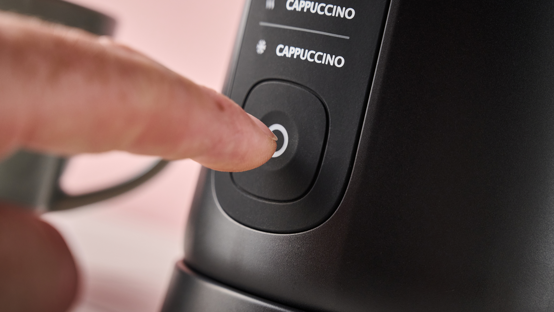 Person pressing button on the Lavazza MilkEasy Plus