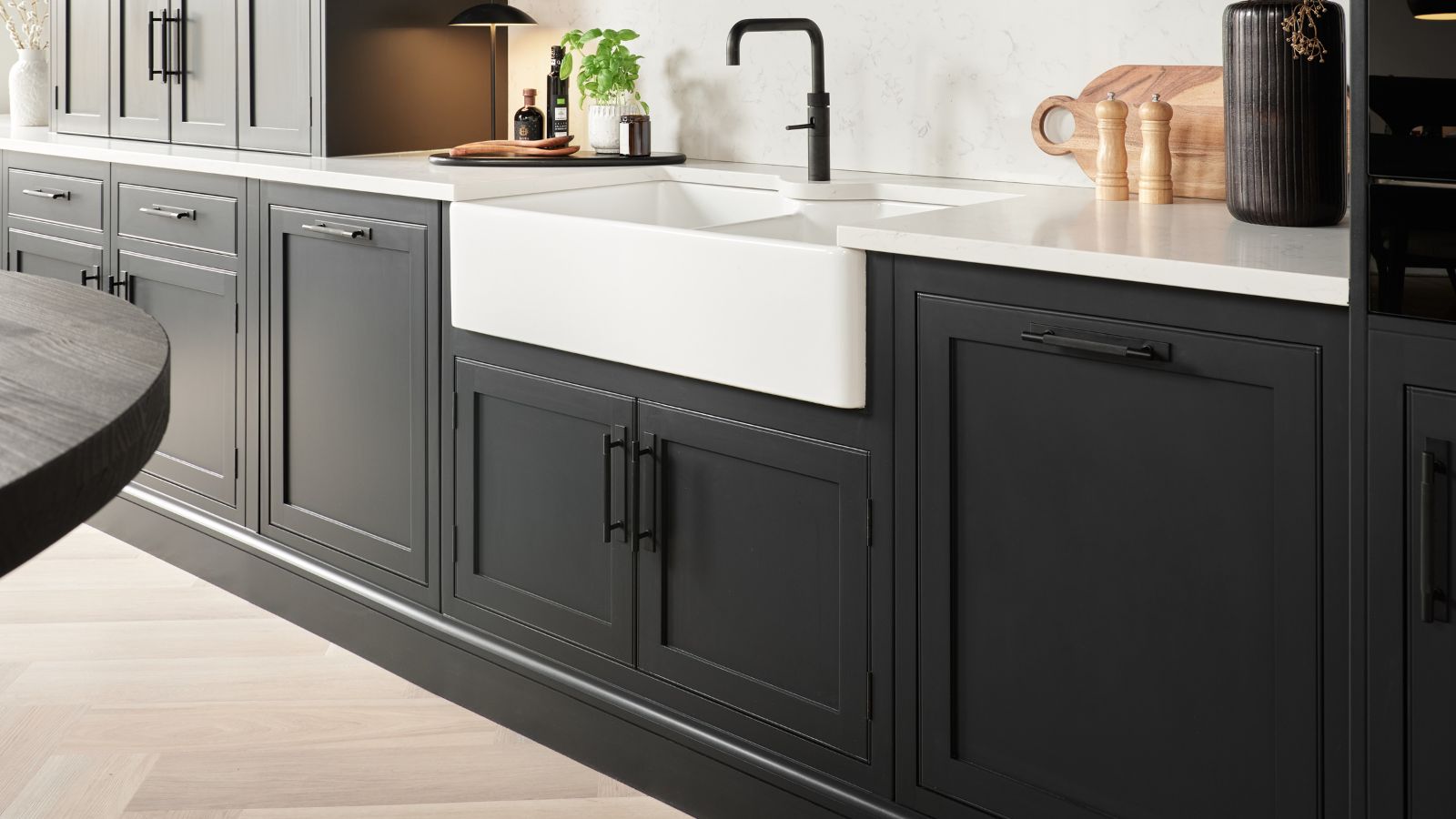 Dark shaker kitchen with white worktop and farmhouse sink