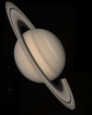 Saturn and three moons, Tethys, Dione and Rhea, seen by a Voyager spacecraft on August 4, 1982, from a distance of 13 million miles.