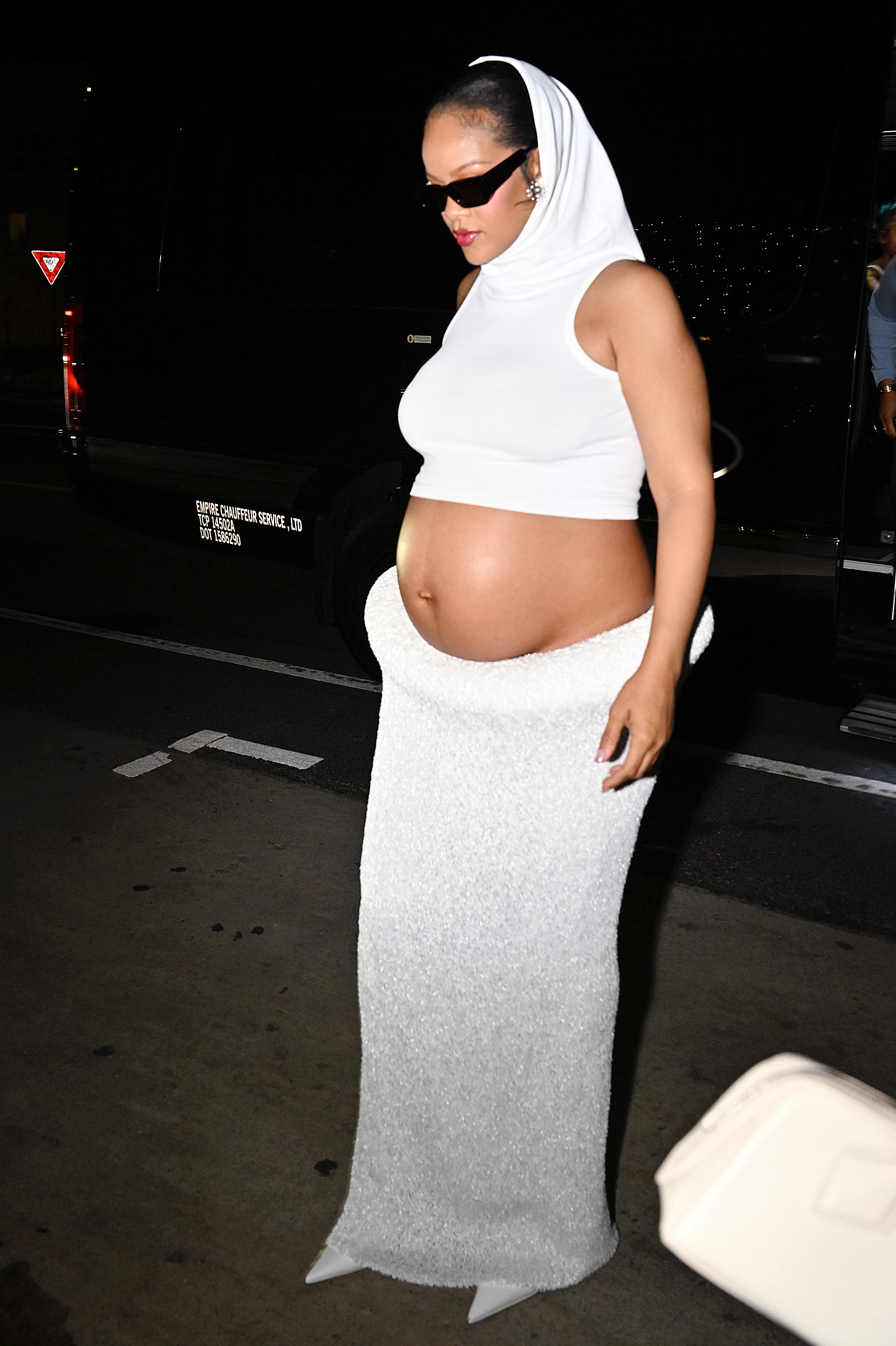 Rihanna exiting her car in a white knit skirt and matching top