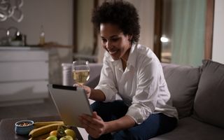 Happy woman with a drink and an ipad