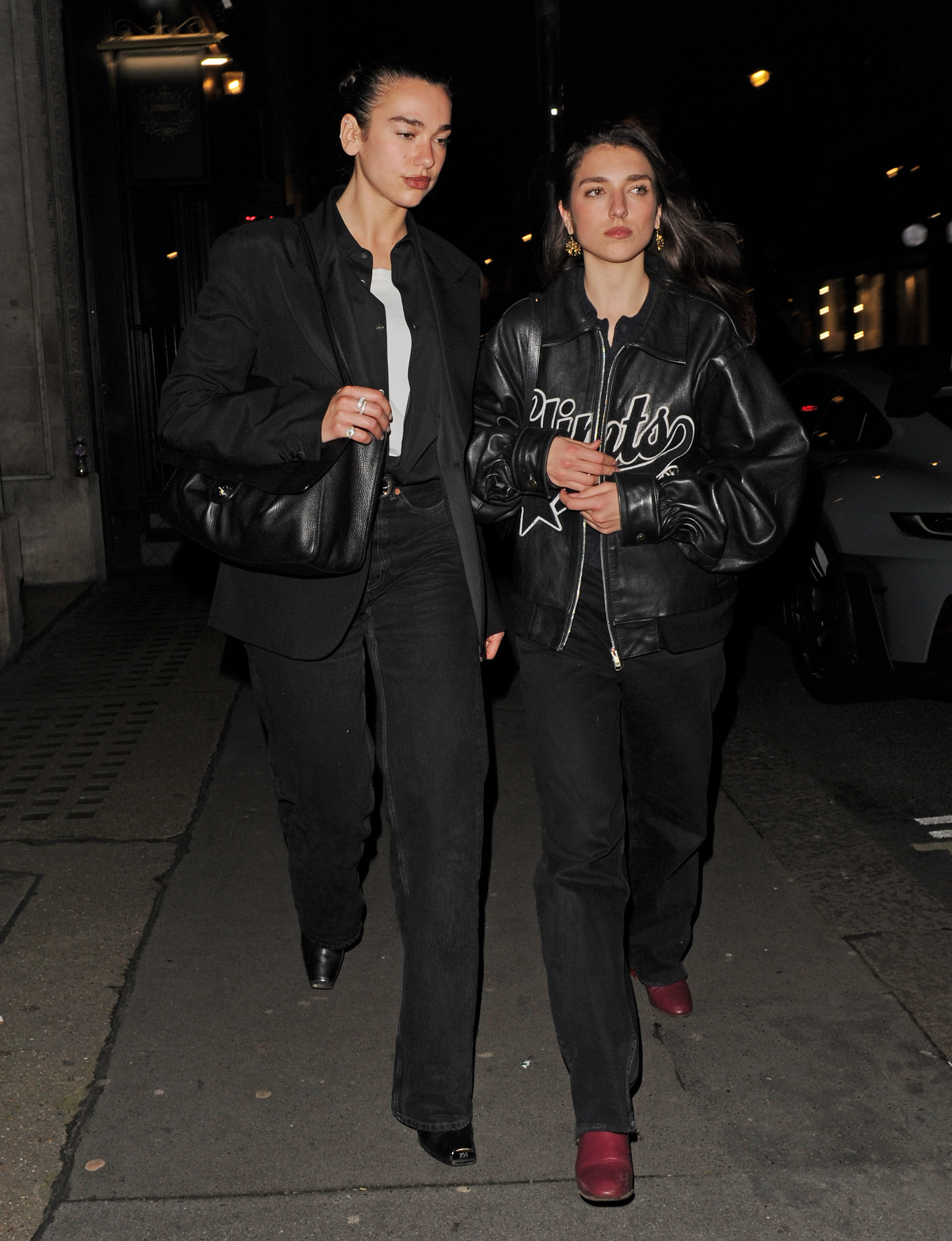 Dua Lipa wears stove pipe jeans with square-toe boots.