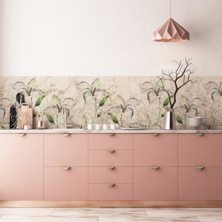 kitchen with wallpaper splashback, pink cabinets, paper pendant, chopping boards, brass tap and accessories