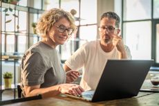 A couple discussing their finances in front of a laptop