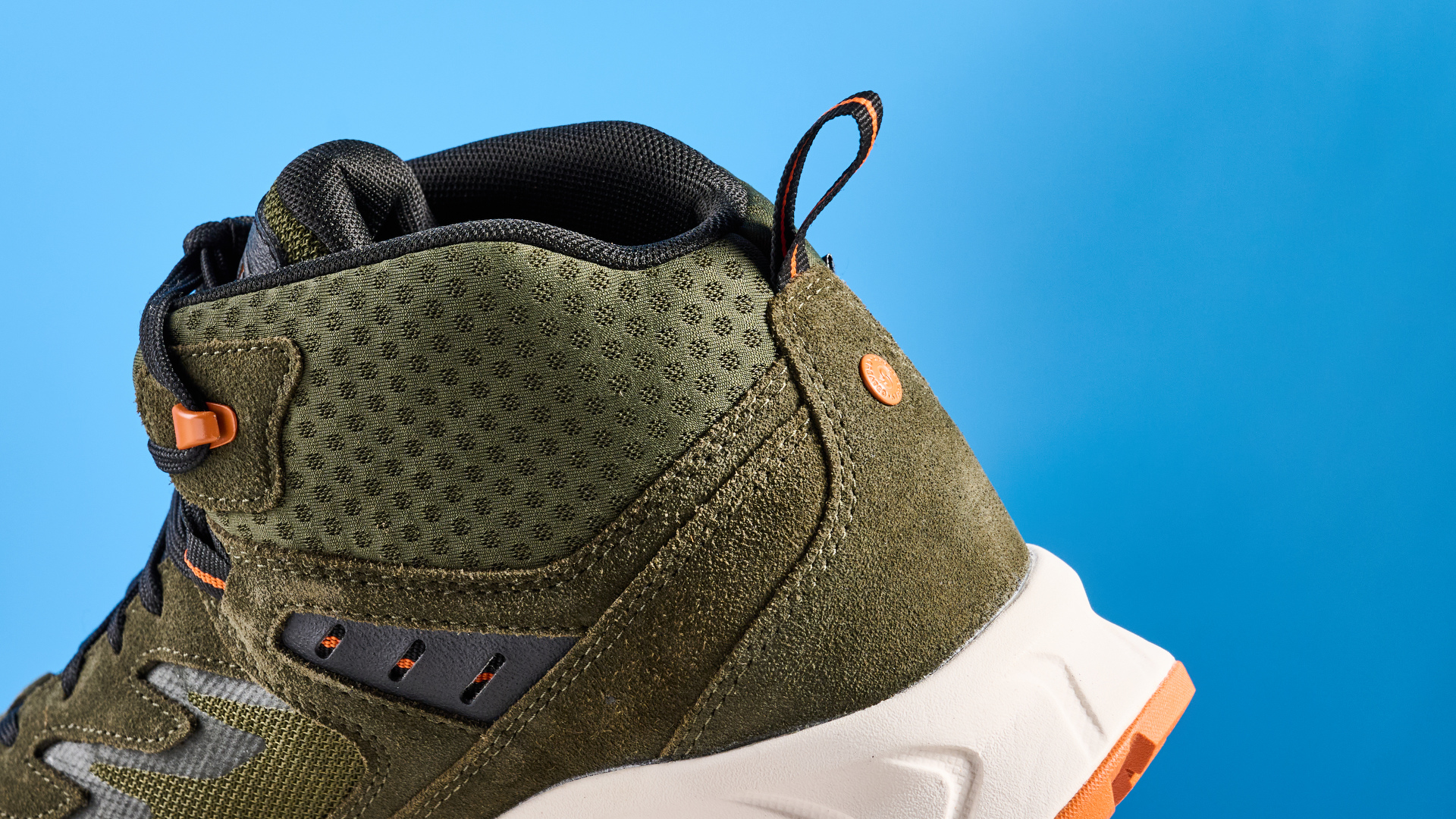The Keen Hightrail Mid boots ankle against a blue background
