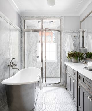 bathroom with zinc bathtub and gray cabinets