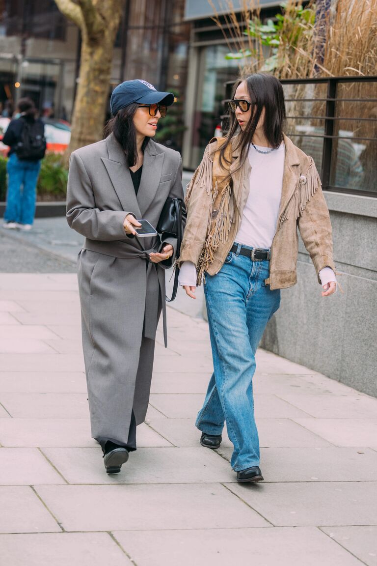 A guest attending shows during London Fashion Week wearing jeans with ankle boots.