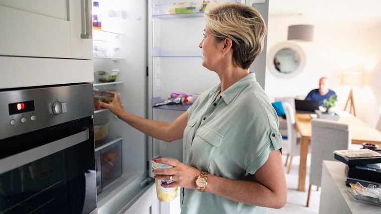 woman looking in her fridge