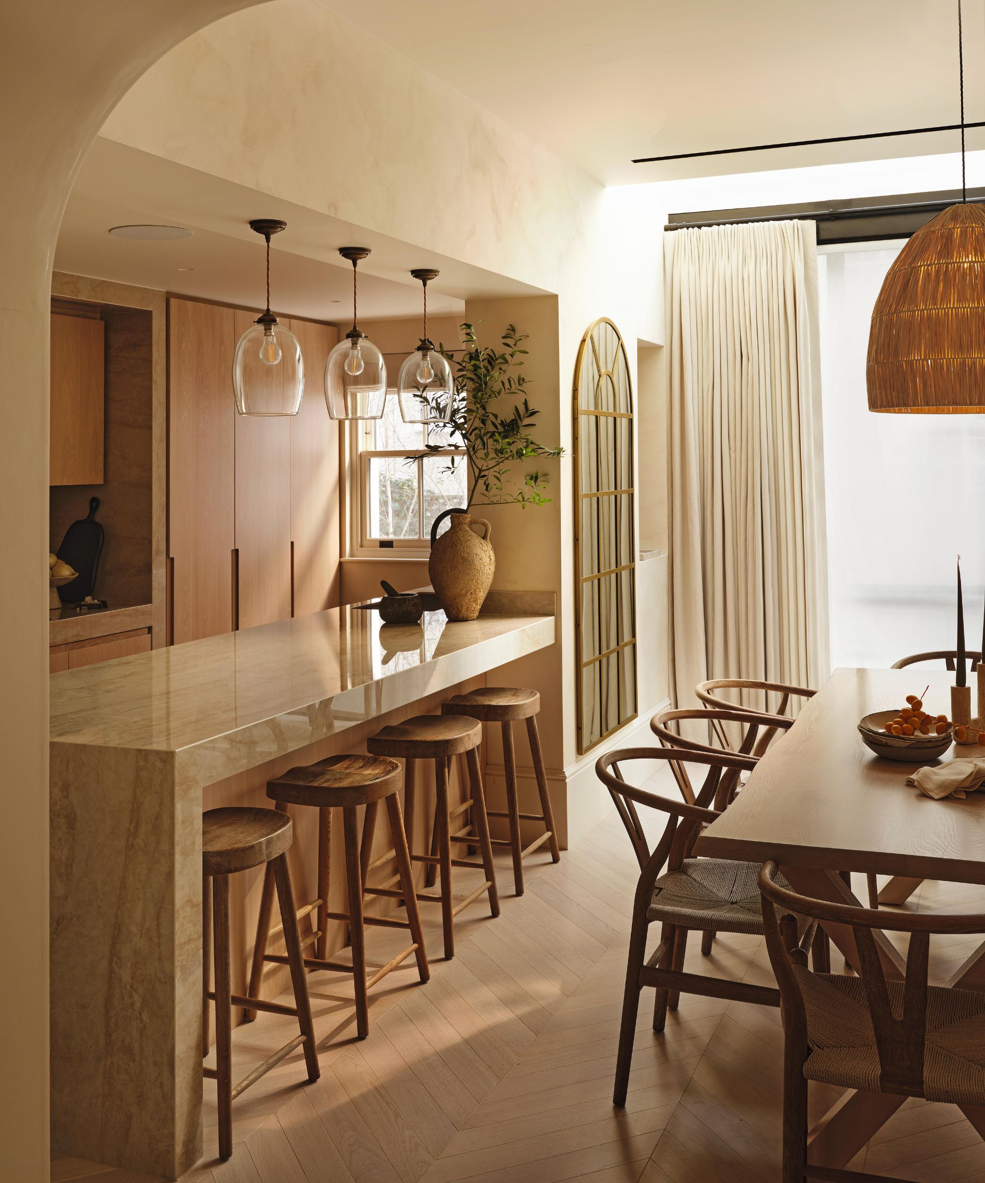a wabi-sabi style kitchen with oak cabinetry, kitchen island and dining area