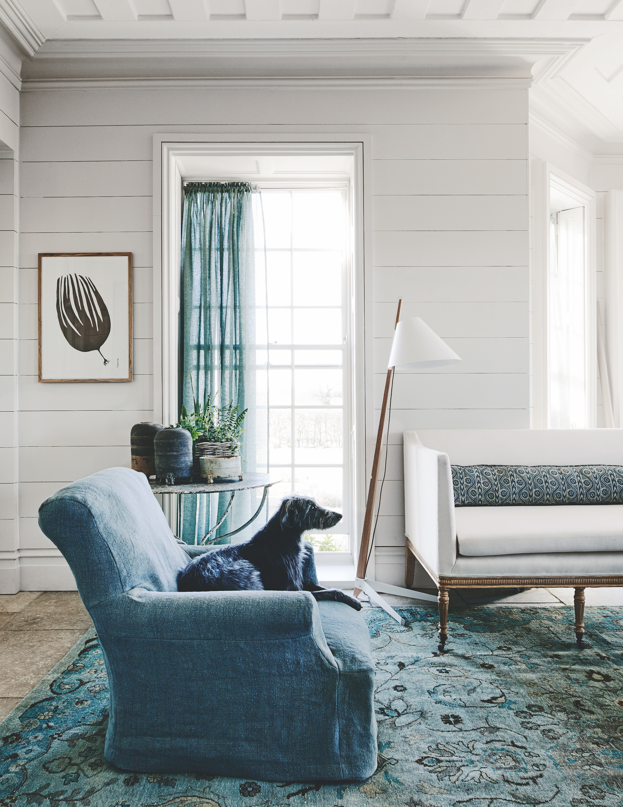 living room with sofa and armchair and blue curtains