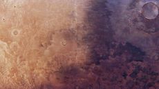 Aerial photo of Mars showing a dark shadow-like patch of ground