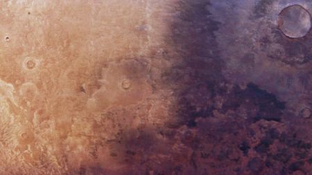 Aerial photo of Mars showing a dark shadow-like patch of ground