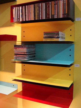 Five multi-coloured shelves, two containing CD cases.