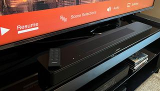 Bose Smart Soundbar 600 on TV stand with remote control