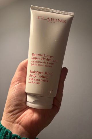 clarins body moisturiser being held