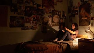 Ellie (Bella Ramsey) reading comics on her bed in The Last Of Us episode 7