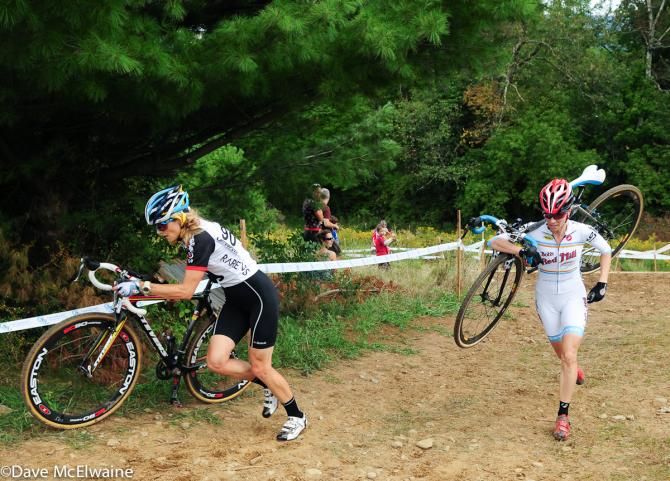 Natasha Elliot (Rare Vos Racing) pushing her bike as Mo Bruno-Roy passed her with a shouldered bike