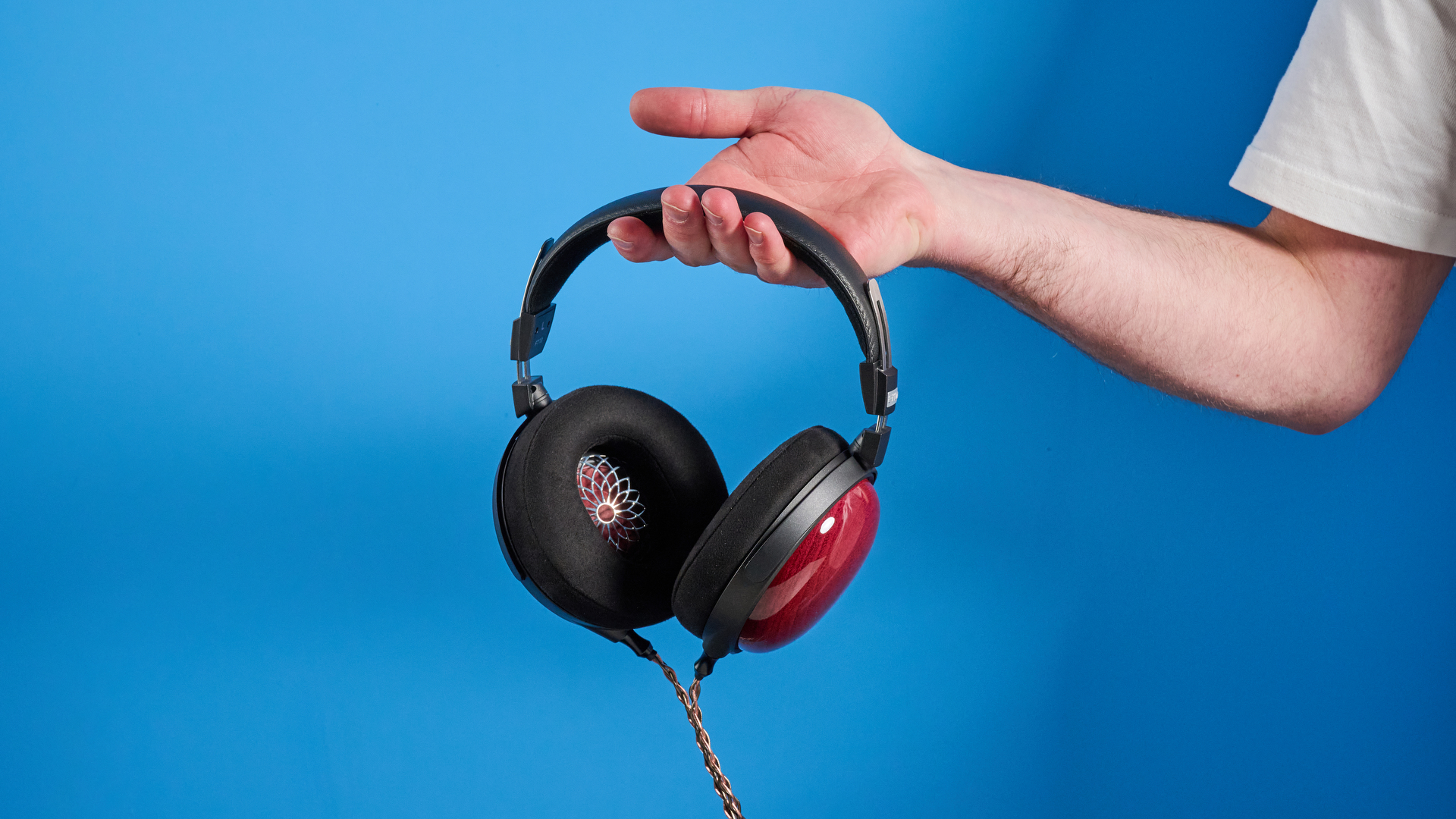 the fiio ft13 wired headphones with wood cups and copper cable photographed against a blue background